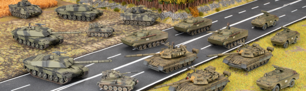 Convoy of green tanks and armored vehicles on a two lane road in a rural battlefield
